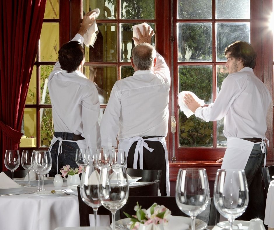 Waiters cleaning windows